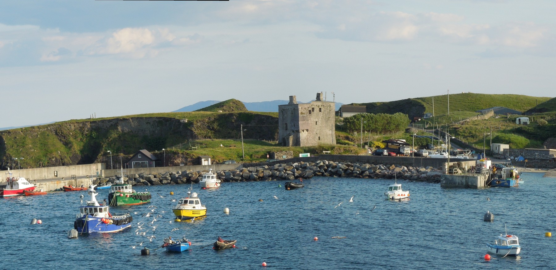 The island's main harbour overlooked by Gr�inne Uaile's tower house which dates from about 1500.